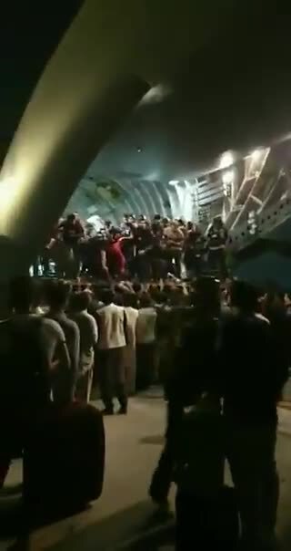 NOW - People boarding an evacuation flight at #Kabul airport while apparent gunfire is seen in the s...