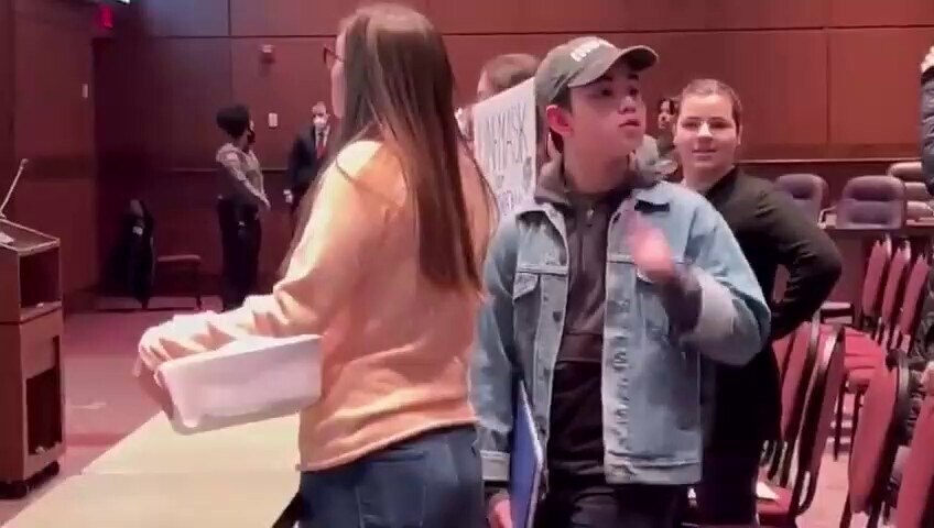 Students whose families oppose mask mandates arrive at a Loudoun County School Board meeting carryin...