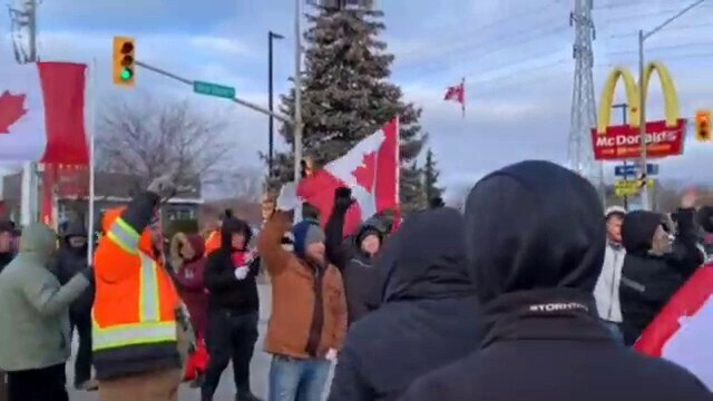 Protesters at ambassador bridge break out into the Canadian national anthem as the police move in to...