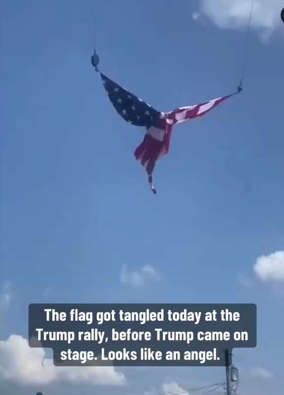 The flag got tangled today at the Trump rally, before Trump came on stage. Looks like an angel.