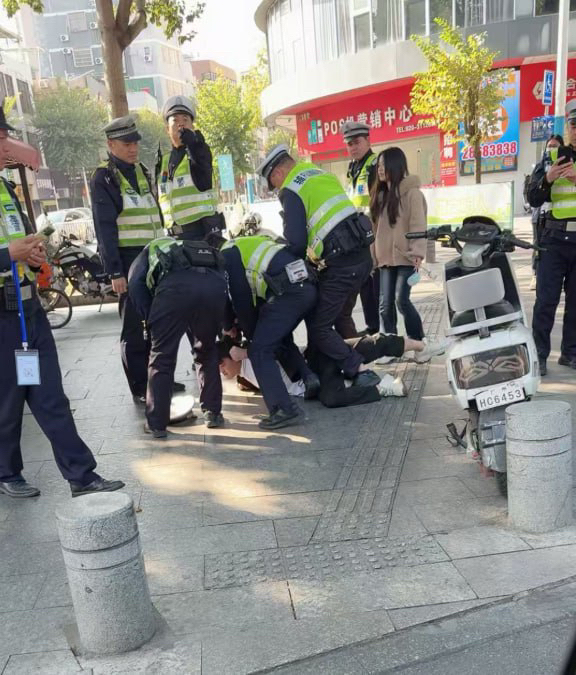 广州番禺，一名男子为了保护自己的电动车，被数名交警制服在地
