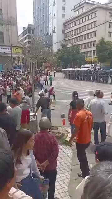 信宜市政府门前
村民与防暴警察对峙，几名老人向防暴警察投掷砖块

2026年3月19日，广东茂名信宜，抗议政府修建殡仪馆的村民再次来到市政府前，用鸡蛋砸向门前的防暴警察
