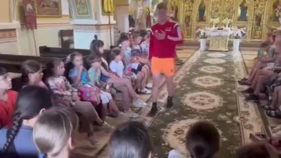 🇺🇦 Un jeune homme en short et t-shirt de sport se promène dans une église orthodoxe et force des e...